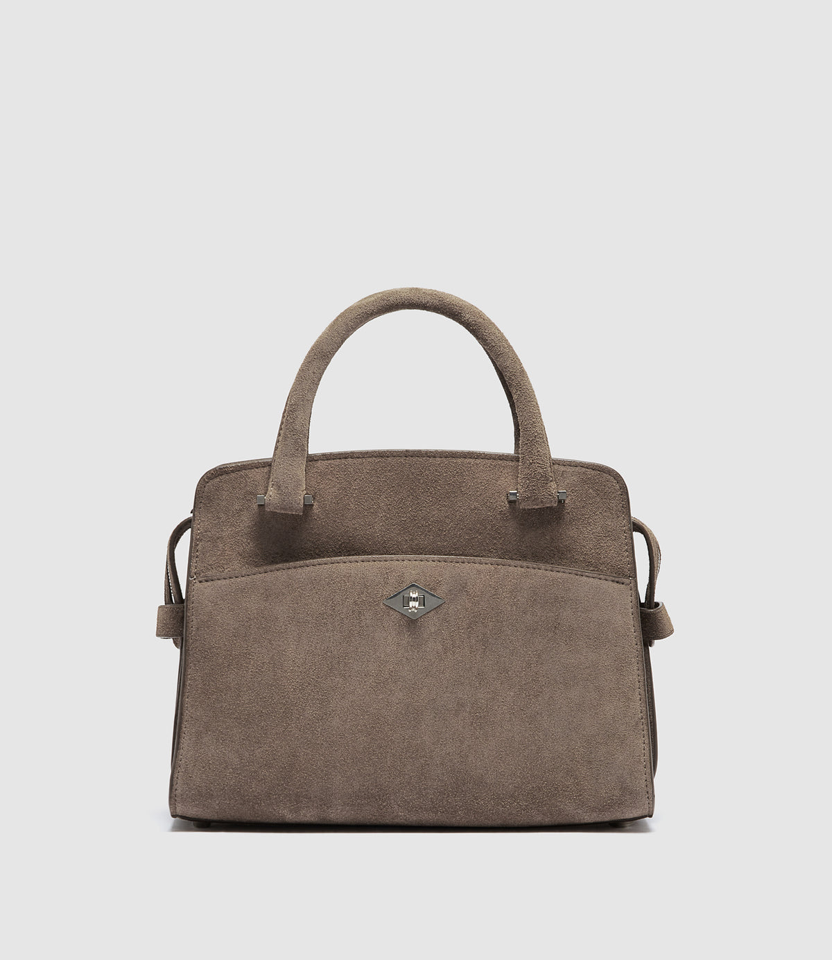 A taupe brown suede handbag with dual top handles, a front slip pocket, and a small silver-tone diamond-shaped logo clasp, shown against a light gray background.